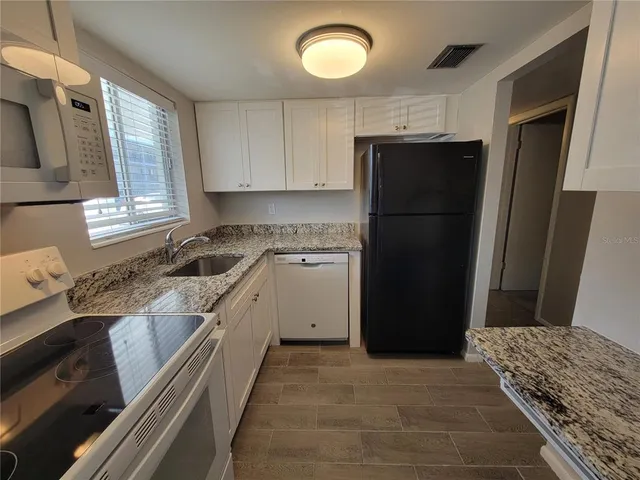 a kitchen with a refrigerator and a stove top oven