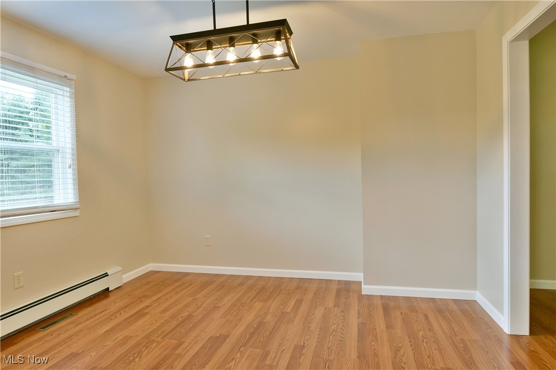 2153 Stillwagon Road Southeast Warren, OH 44484 - Photo 11 of 50 Spare room with baseboard heating, light wood finished floors, and baseboards