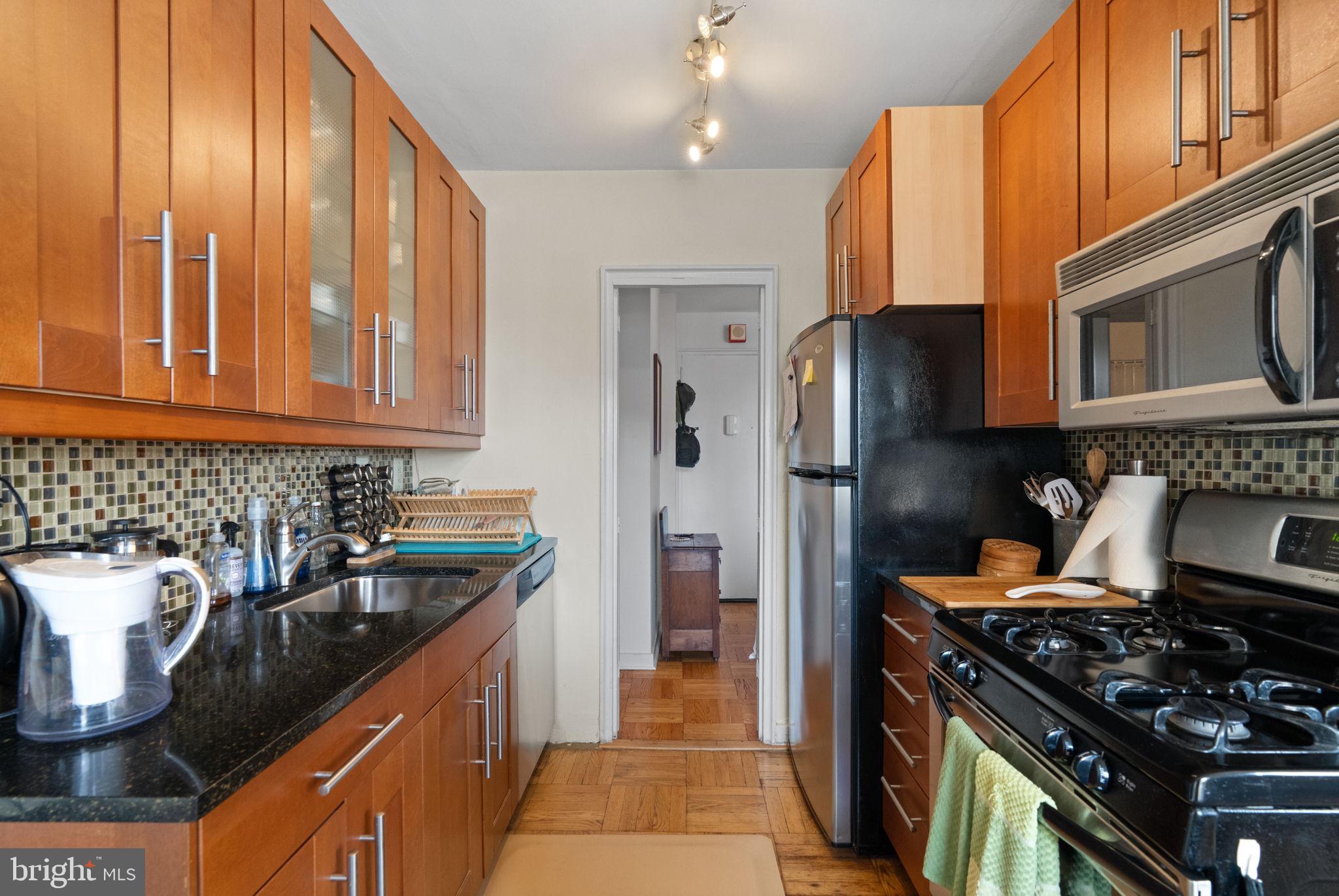 2601 Pennsylvania Avenue, Unit 1132 Philadelphia, PA 19130 - Photo 20 of 28 a kitchen with stainless steel appliances granite countertop a stove a refrigerator and a sink
