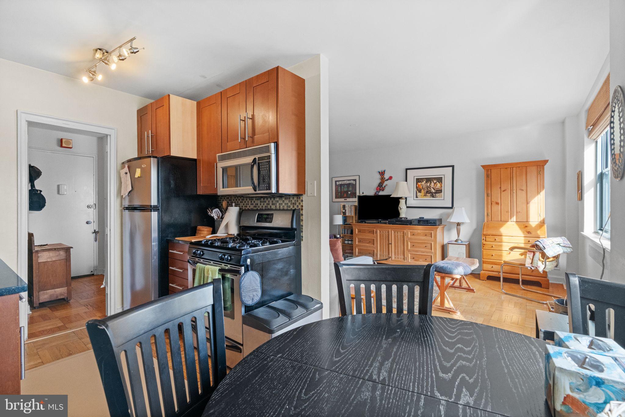 2601 Pennsylvania Avenue, Unit 1132 Philadelphia, PA 19130 - Photo 25 of 28 a open kitchen with stainless steel appliances granite countertop a refrigerator dining table and chairs