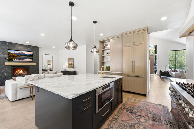 3027 Homestead Road Park City, UT 84098 - Photo 7 of 62 Open-concept living space featuring a central kitchen island with a built-in microwave, integrated full-height refrigerator, and a gas range