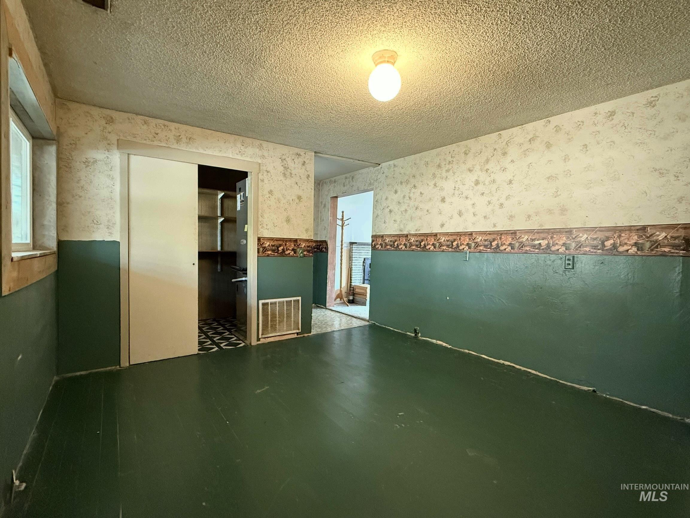 2395 Villard Street Pomeroy, WA 99347 - Photo 17 of 50 Unfurnished room with wallpapered walls, a textured ceiling, and a wainscoted wall