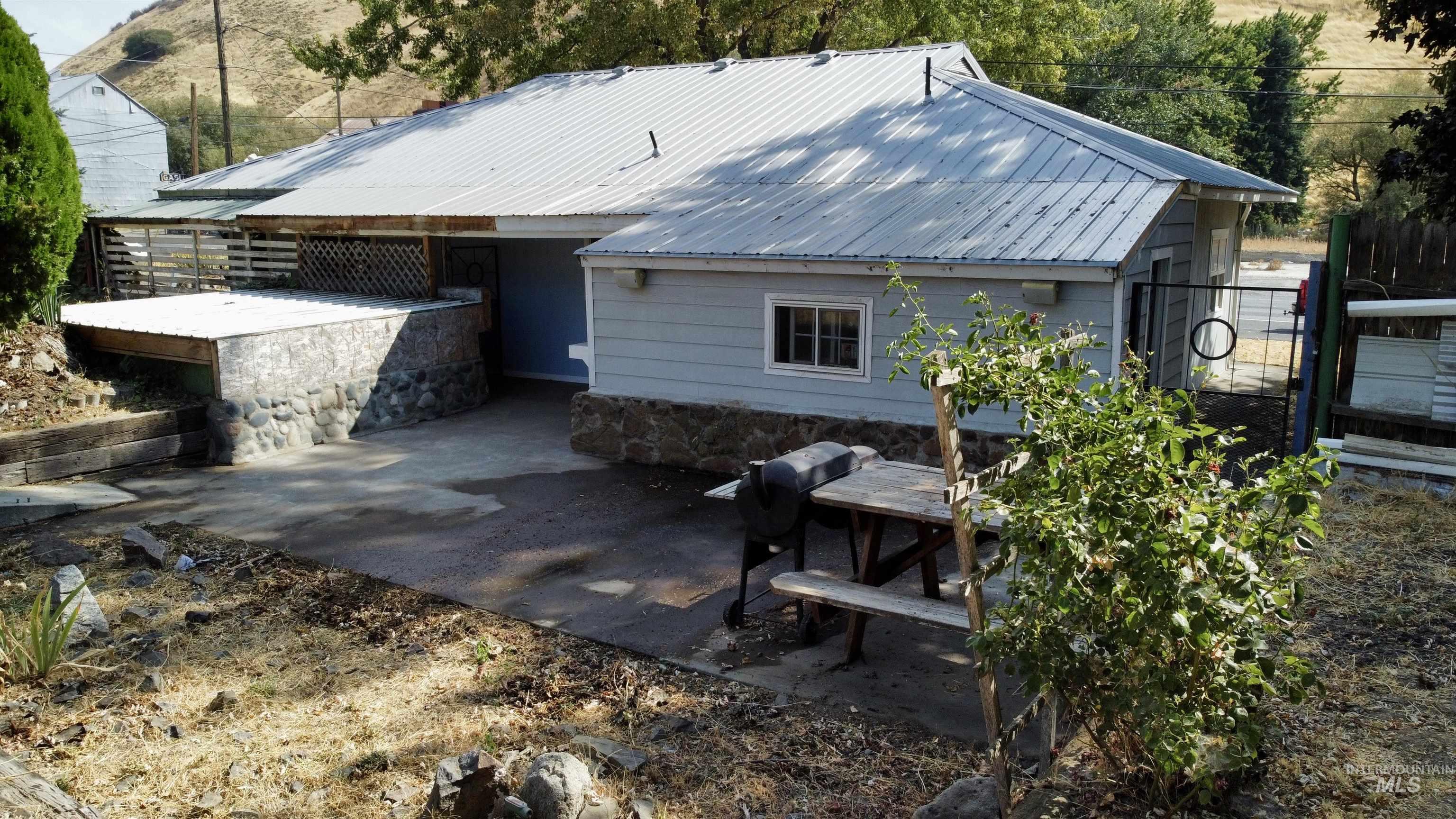 2395 Villard Street Pomeroy, WA 99347 - Photo 38 of 50 Rear view of property featuring a patio area, a metal roof, and a chimney