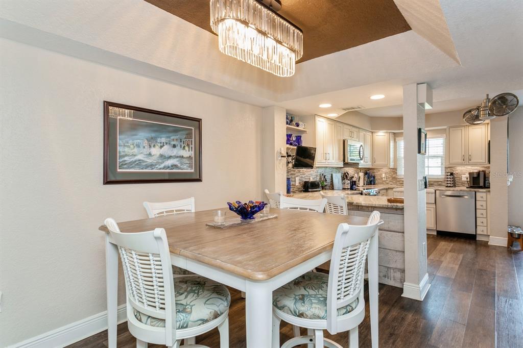9166 Blind Pass Road St. Pete Beach, FL 33706 - Photo 13 of 37 a view of a dining room with furniture and wooden floor