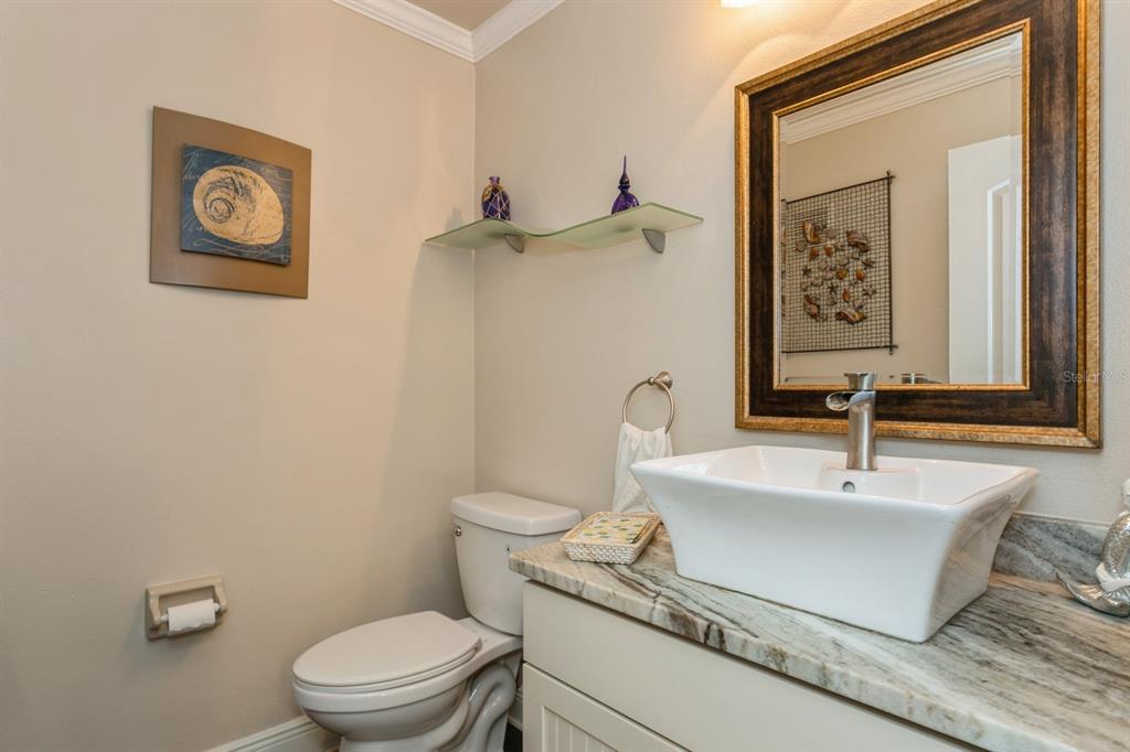9166 Blind Pass Road St. Pete Beach, FL 33706 - Photo 15 of 37 a bathroom with a sink a toilet and mirror