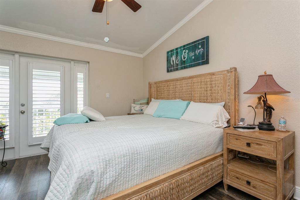 9166 Blind Pass Road St. Pete Beach, FL 33706 - Photo 16 of 37 a bedroom with a bed and wooden floor