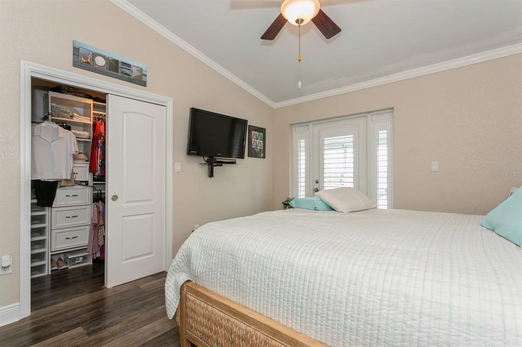 9166 Blind Pass Road St. Pete Beach, FL 33706 - Photo 17 of 37 a bedroom with a bed and a flat screen tv