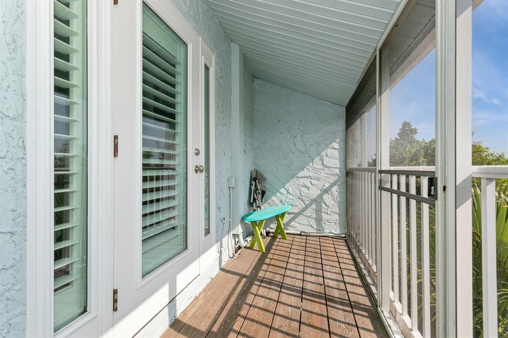 9166 Blind Pass Road St. Pete Beach, FL 33706 - Photo 20 of 37 a view of balcony with wooden floor and fence
