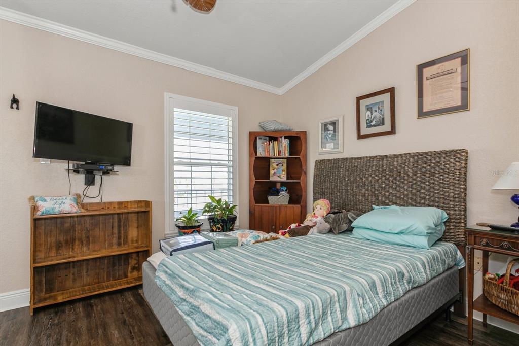 9166 Blind Pass Road St. Pete Beach, FL 33706 - Photo 23 of 37 a bedroom with a bed and a flat screen tv