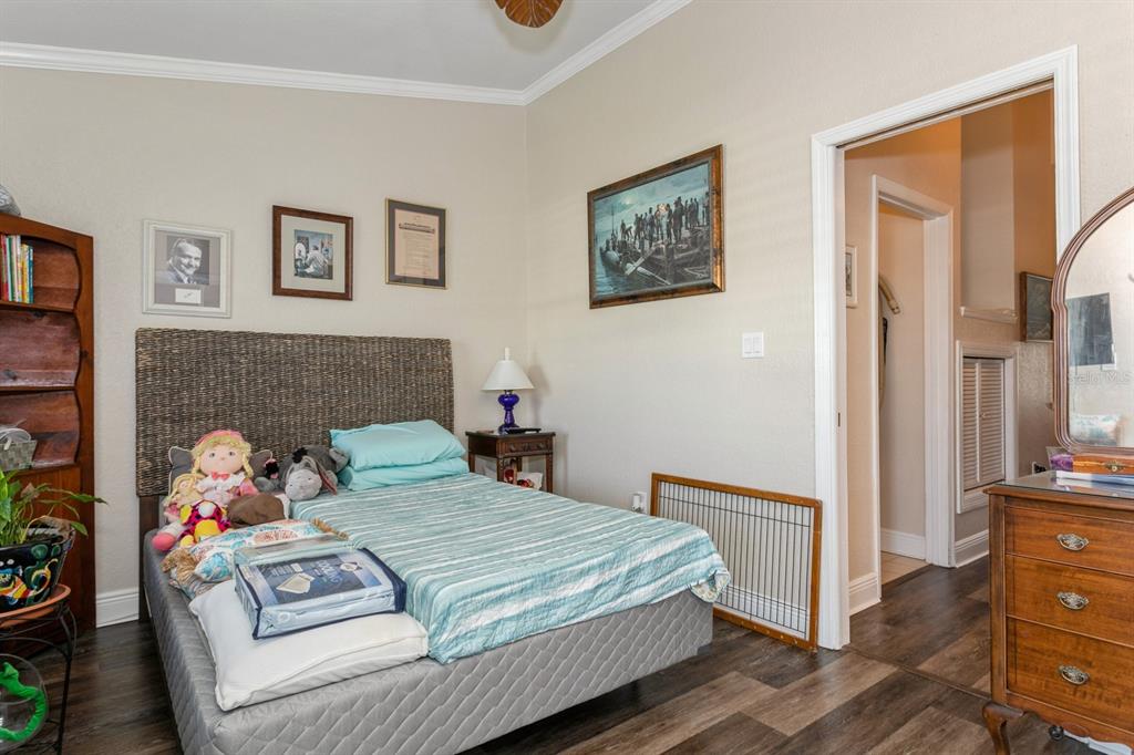 9166 Blind Pass Road St. Pete Beach, FL 33706 - Photo 24 of 37 a bedroom with a bed and wooden floor