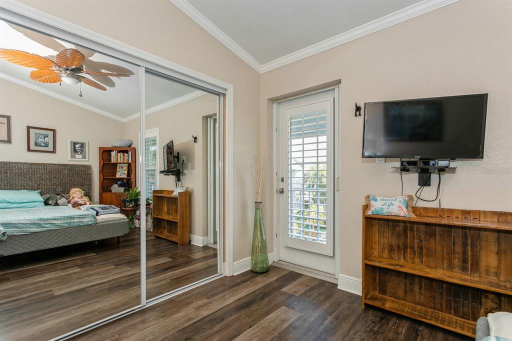 9166 Blind Pass Road St. Pete Beach, FL 33706 - Photo 25 of 37 a bedroom with furniture and a flat screen tv