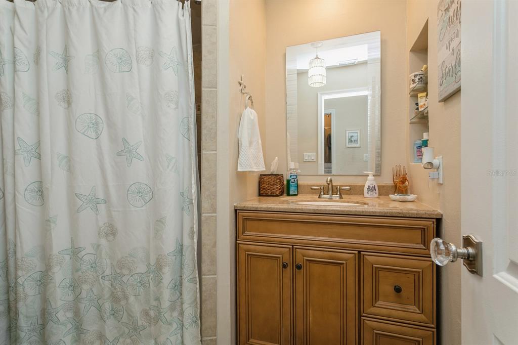9166 Blind Pass Road St. Pete Beach, FL 33706 - Photo 26 of 37 a bathroom with a sink a vanity and a mirror
