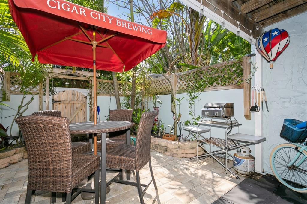 9166 Blind Pass Road St. Pete Beach, FL 33706 - Photo 31 of 37 a patio with a patio table and chairs