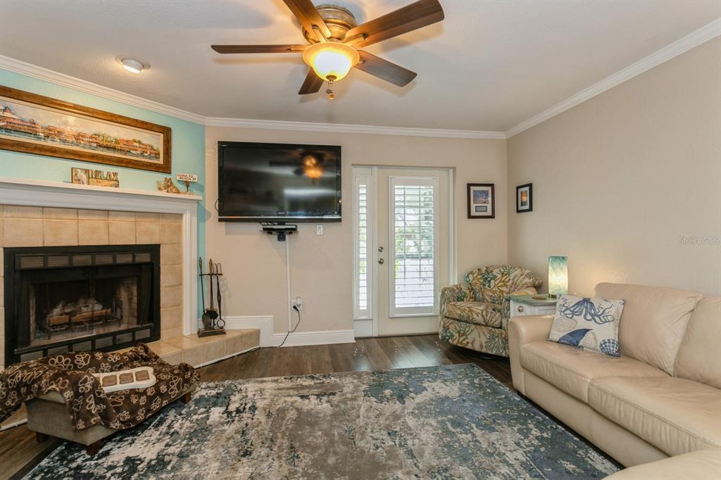 9166 Blind Pass Road St. Pete Beach, FL 33706 - Photo 6 of 37 a living room with furniture a flat screen tv and a fireplace