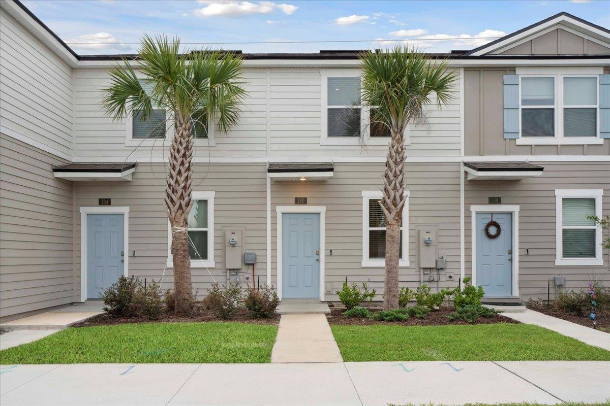 180 Stonegate Avenue St. Augustine, FL 32084 - Photo 1 of 38 a front view of a house with a yard and potted plants