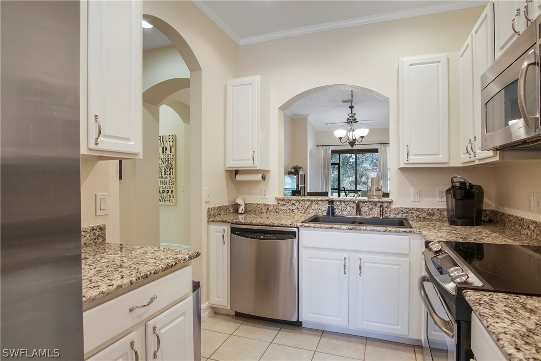 9070 Water Tupelo Road Fort Myers, FL 33912 - Photo 12 of 29 a kitchen with a sink stove and cabinets