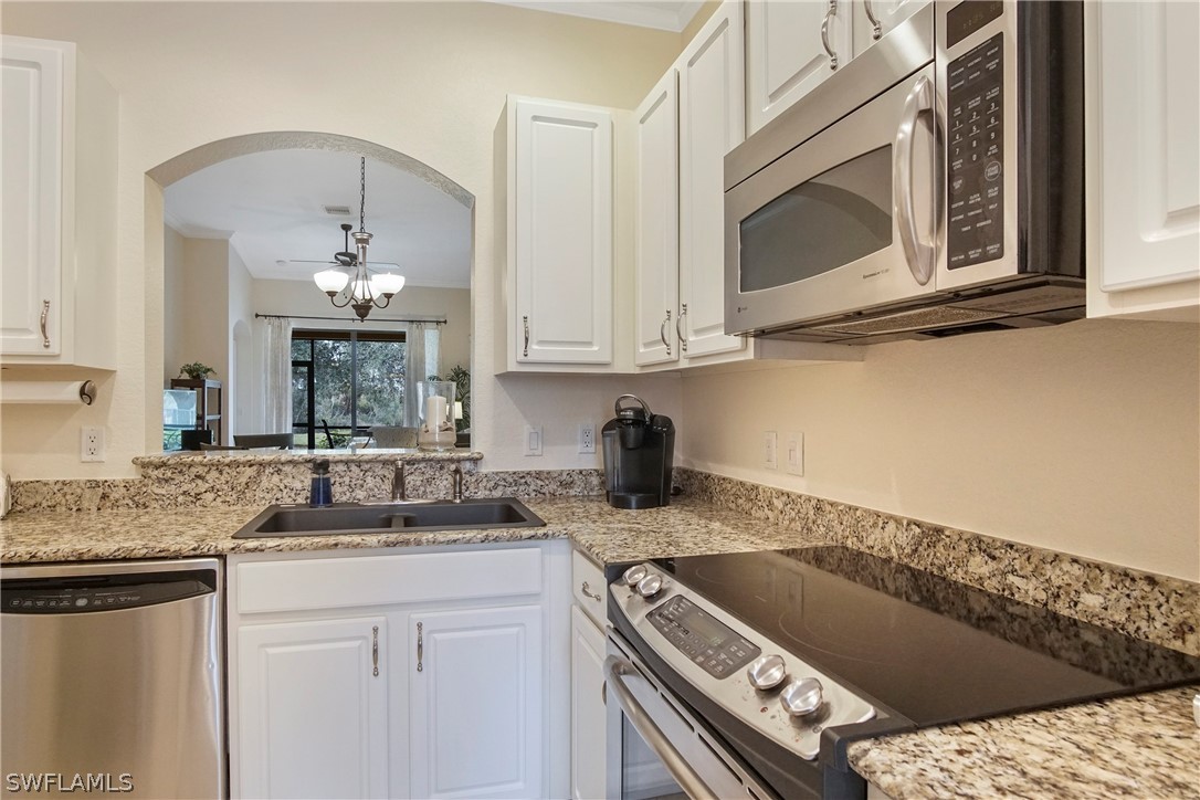 9070 Water Tupelo Road Fort Myers, FL 33912 - Photo 13 of 29 a kitchen with stainless steel appliances granite countertop a sink stove and microwave