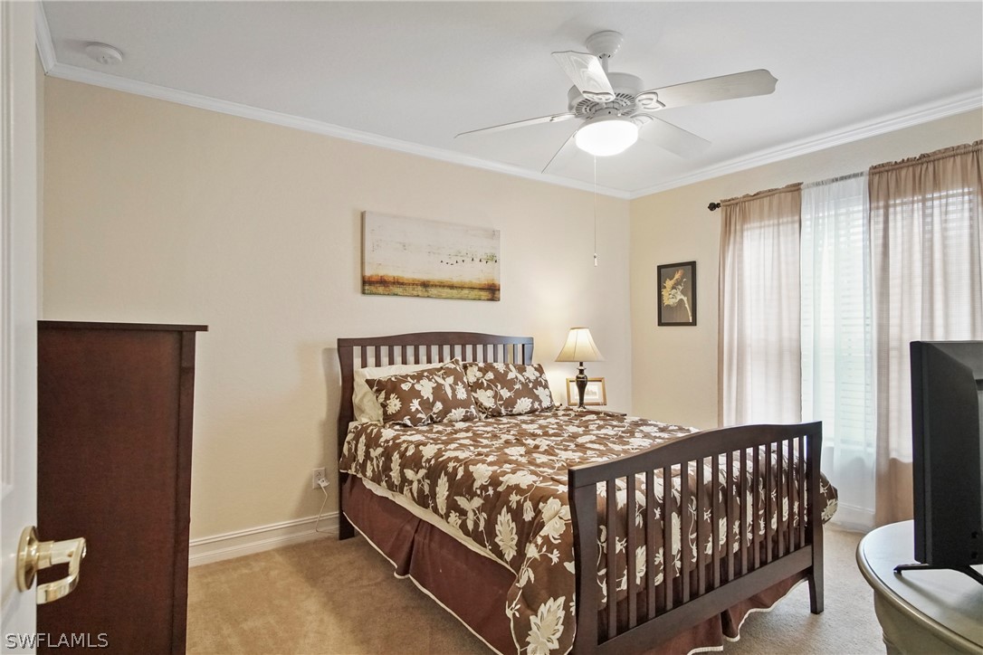 9070 Water Tupelo Road Fort Myers, FL 33912 - Photo 19 of 29 a bedroom with a bed and a chandelier