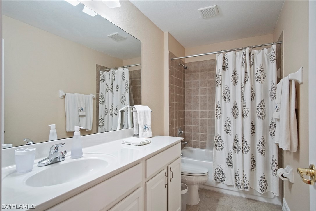 9070 Water Tupelo Road Fort Myers, FL 33912 - Photo 20 of 29 a bathroom with a double vanity sink toilet and shower
