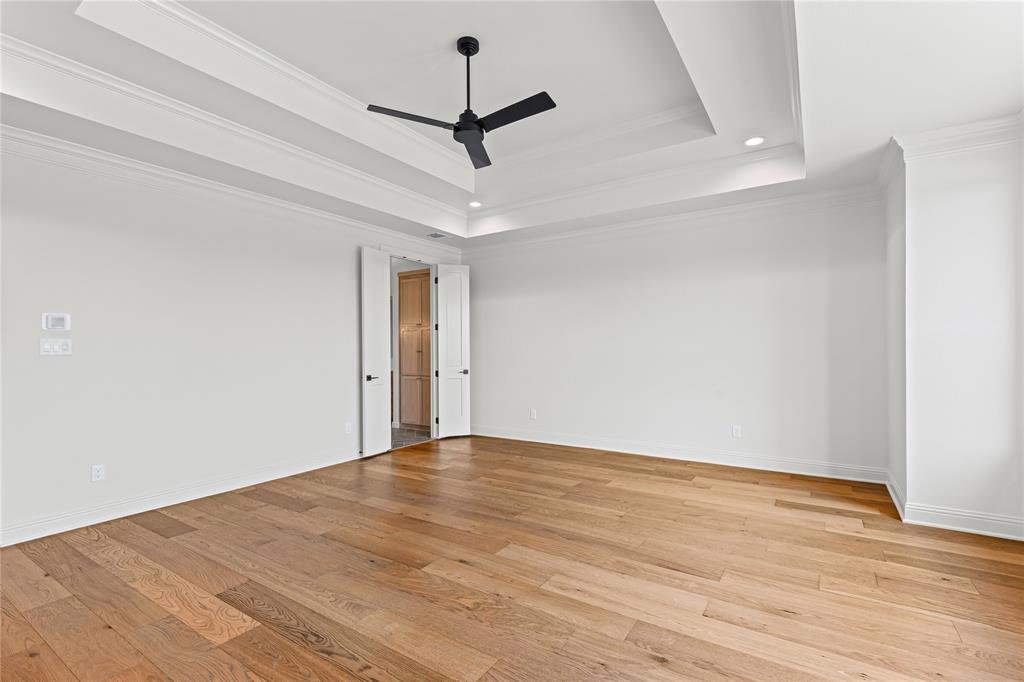 4720 Magnolia Trail Midlothian, TX 76065 - Photo 22 of 40 a view of an empty room with wooden floor and a ceiling fan