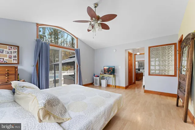 a bedroom with a large bed and a chandelier fan