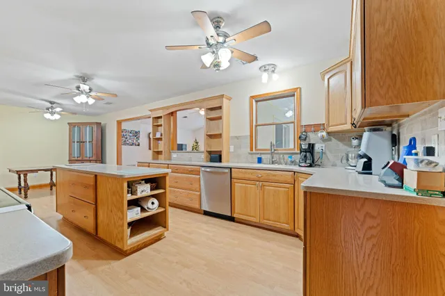 a large white kitchen with cabinets a sink and appliances