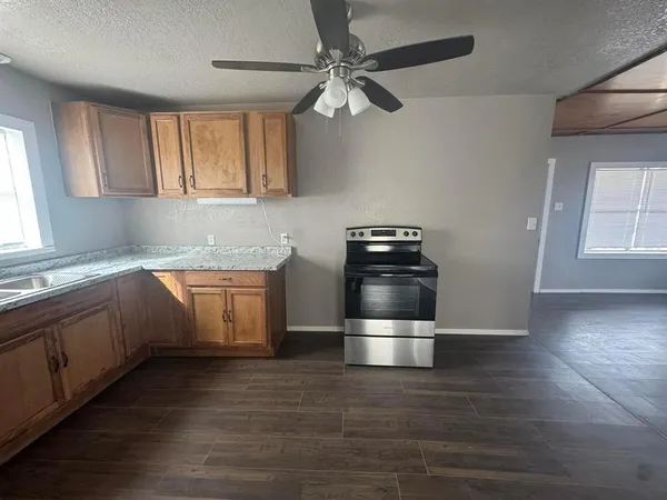 a kitchen with granite countertop white cabinets and white appliances