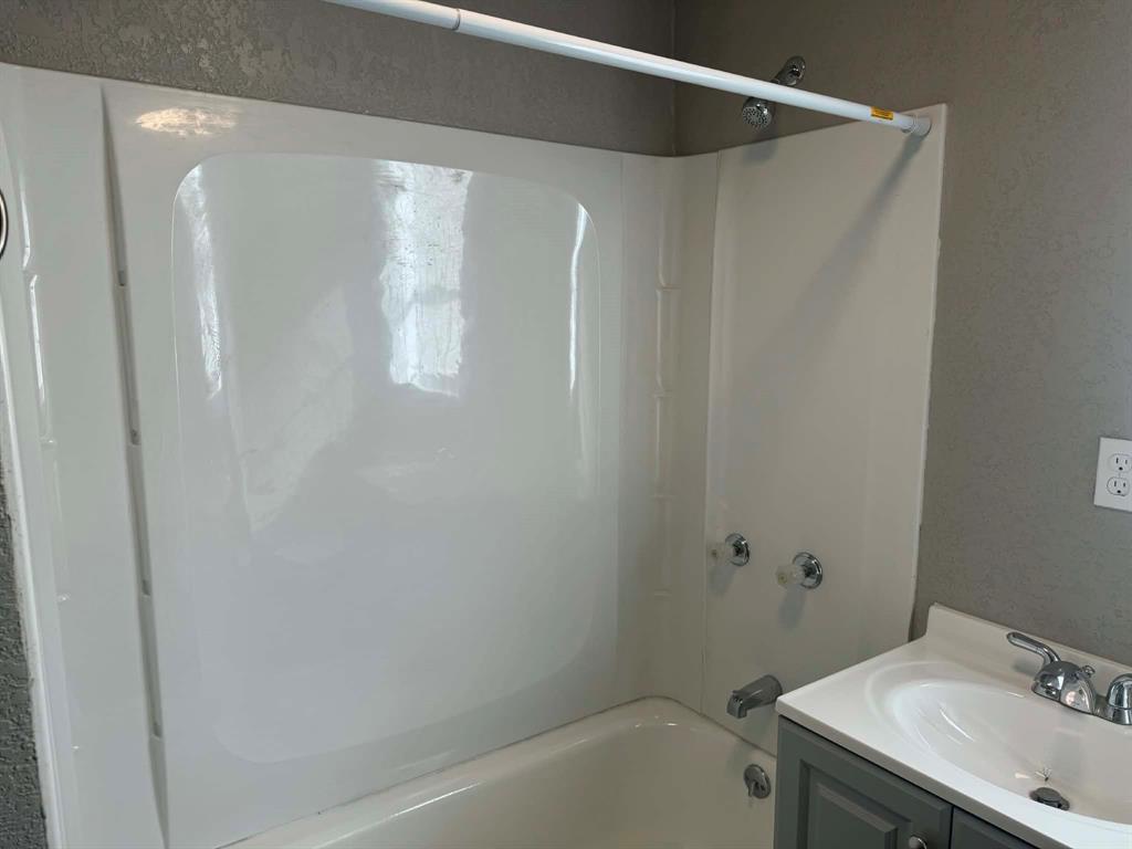 601 South Pine Street Comanche, TX 76442 - Photo 7 of 11 a bathroom with a sink and a mirror