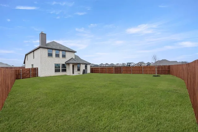 a view of a house with a big yard and large trees
