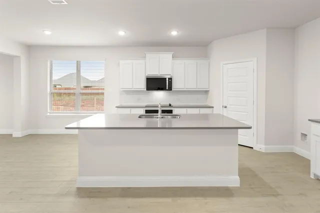 a kitchen with stainless steel appliances granite countertop a sink a stove and a refrigerator