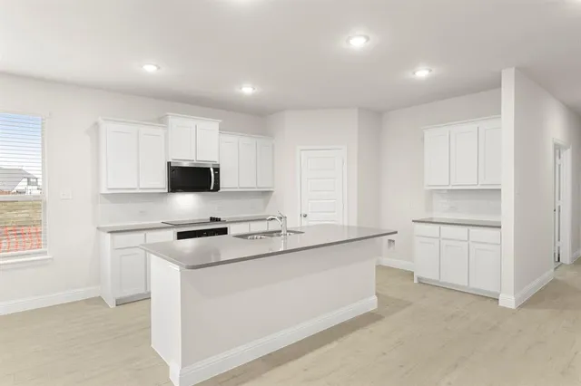 a kitchen with granite countertop white cabinets and white appliances