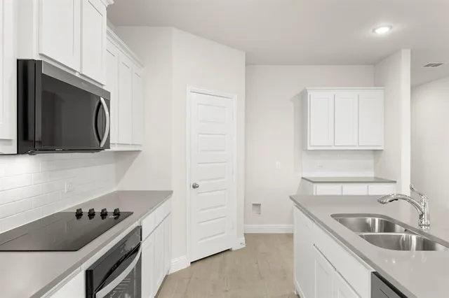 a kitchen with a sink stove and microwave