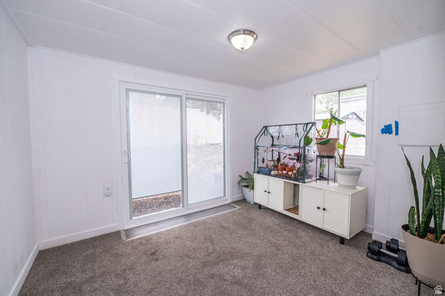 2600 North Hill Field Road, Unit 5 Layton, UT 84041 - Photo 19 of 33 Carpeted interior space featuring white paneled walls, a sliding glass door, and an overhead flush-mount light fixture
