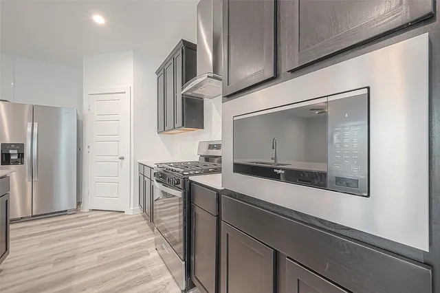 a kitchen with stainless steel appliances granite countertop a refrigerator and a stove