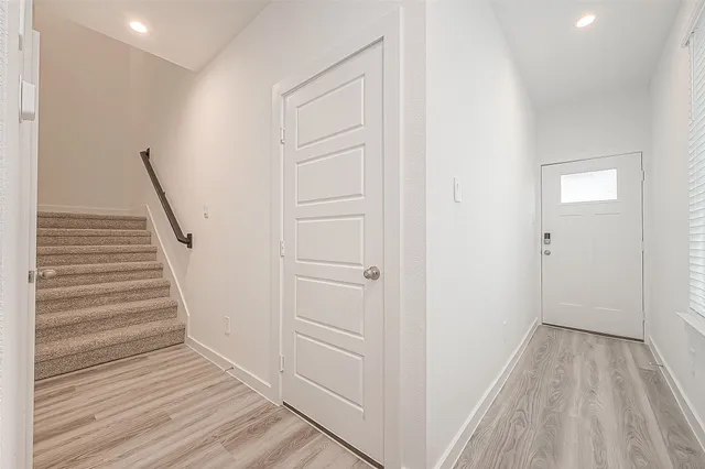 a view of a hallway with wooden floor and entryway
