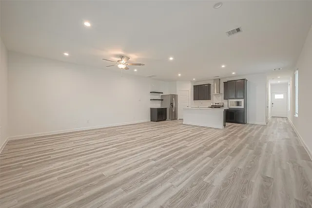 a view of an empty room with a kitchen