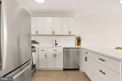 a kitchen with white cabinets and white appliances