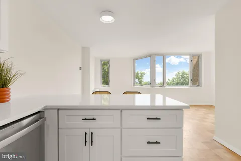 a kitchen with stainless steel appliances a refrigerator a stove a sink and white cabinets with wooden floor