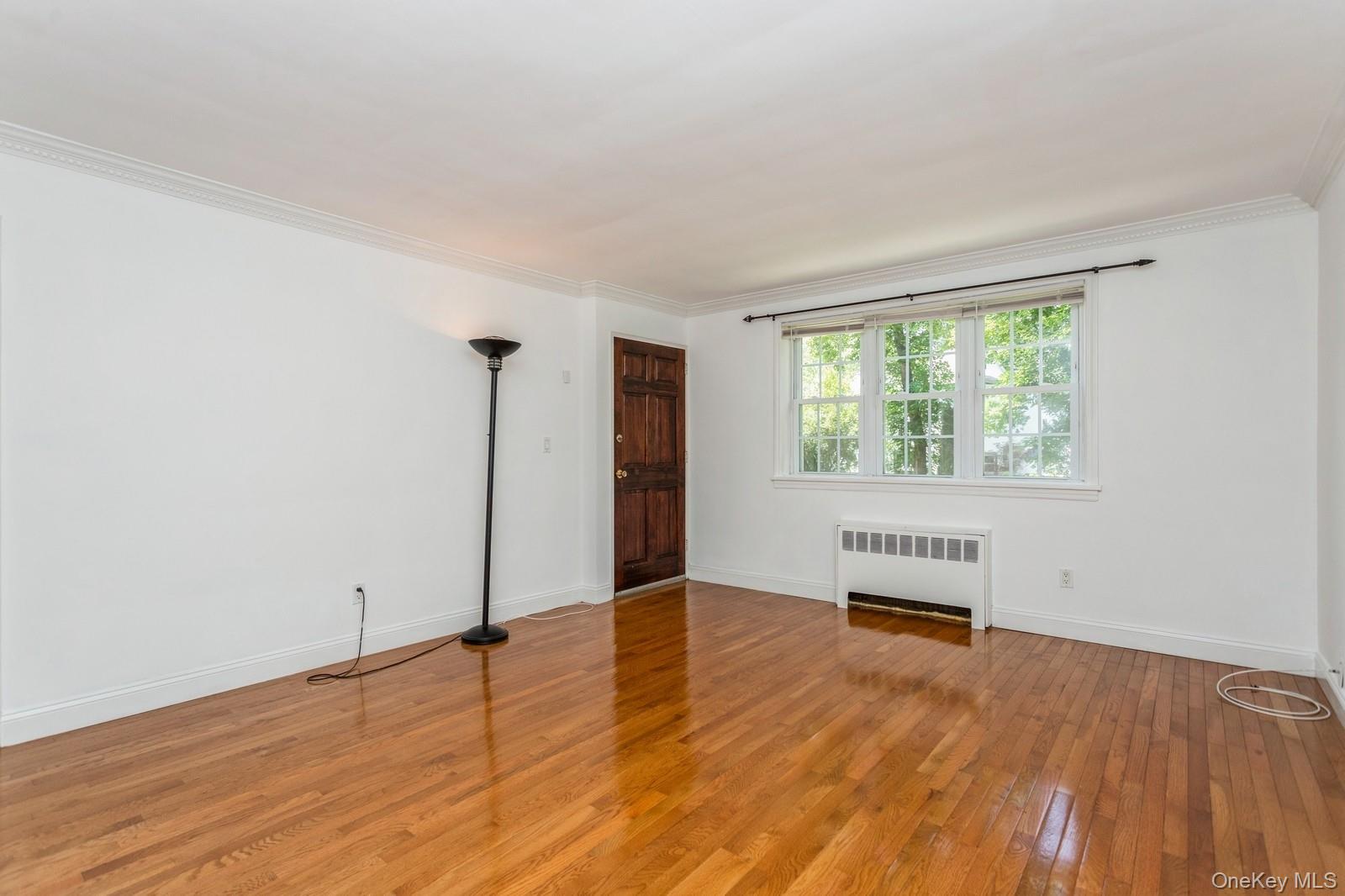 51 Cross Street, Unit 3A Yonkers, NY 10708 - Photo 5 of 17 Unfurnished room featuring radiator heating unit, hardwood / wood-style floors, and crown molding