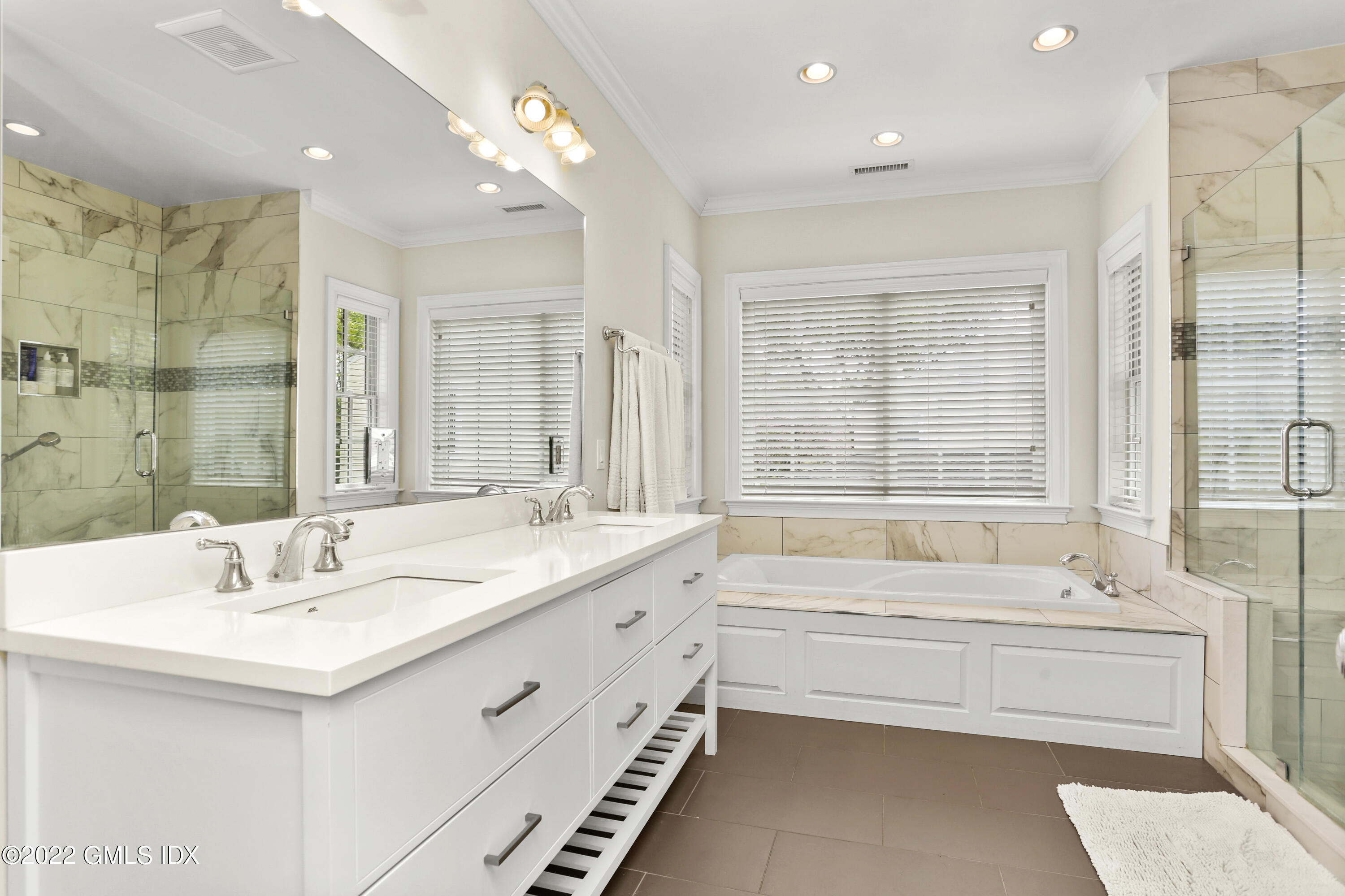 2 Pierce Road Riverside, CT 06878 - Photo 15 of 26 a bathroom with a double vanity sink large mirror and a bathtub