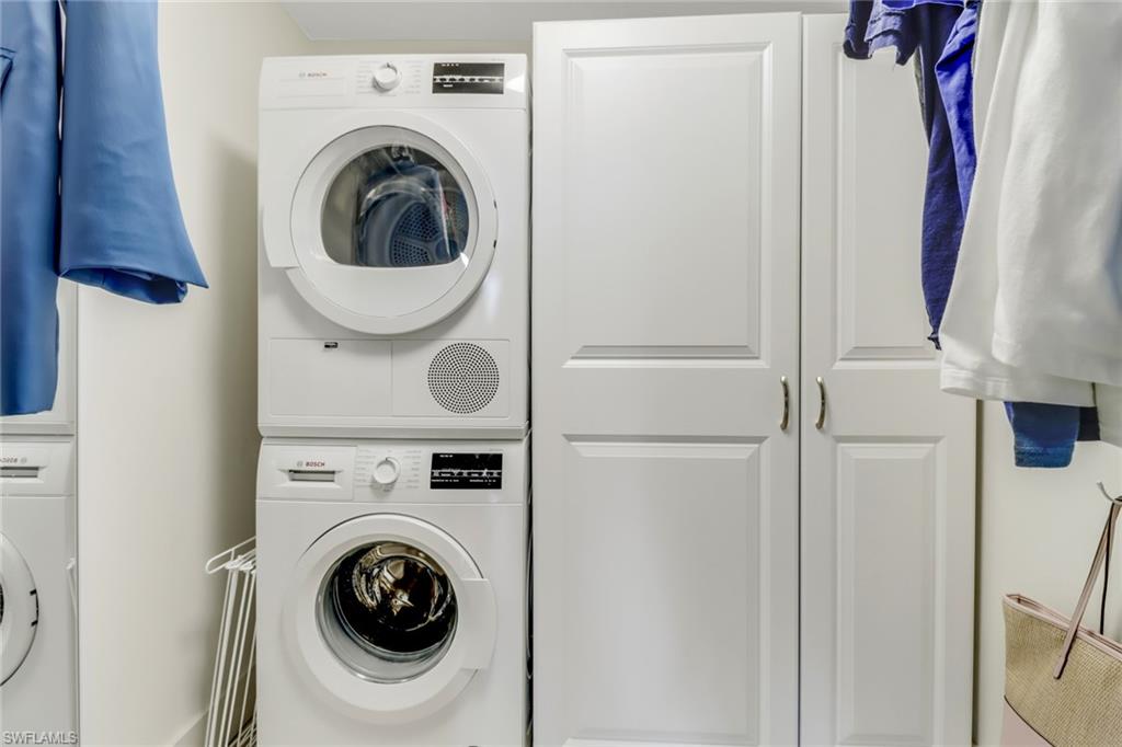 3055 Riviera Drive, Unit 201 Naples, FL 34103 - Photo 12 of 18 Laundry area featuring estacked washer and dryer inside the walk in closet