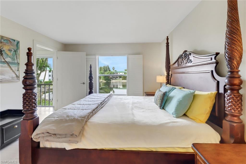 3055 Riviera Drive, Unit 201 Naples, FL 34103 - Photo 9 of 18 Primary bedroom has a peaceful lake view, walk in closet and en suite bathroom.