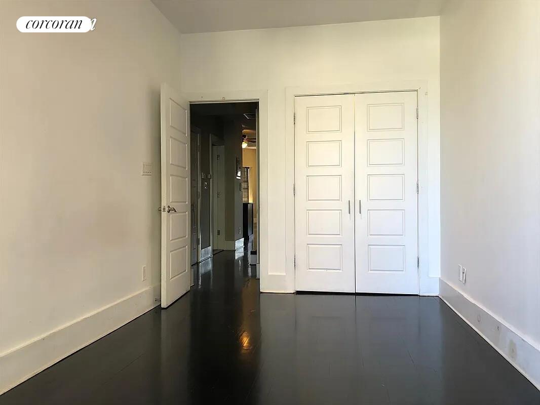 764 St Nicholas Avenue, Unit PH Manhattan, NY 10031 - Photo 10 of 14 an empty room with wooden floor and windows