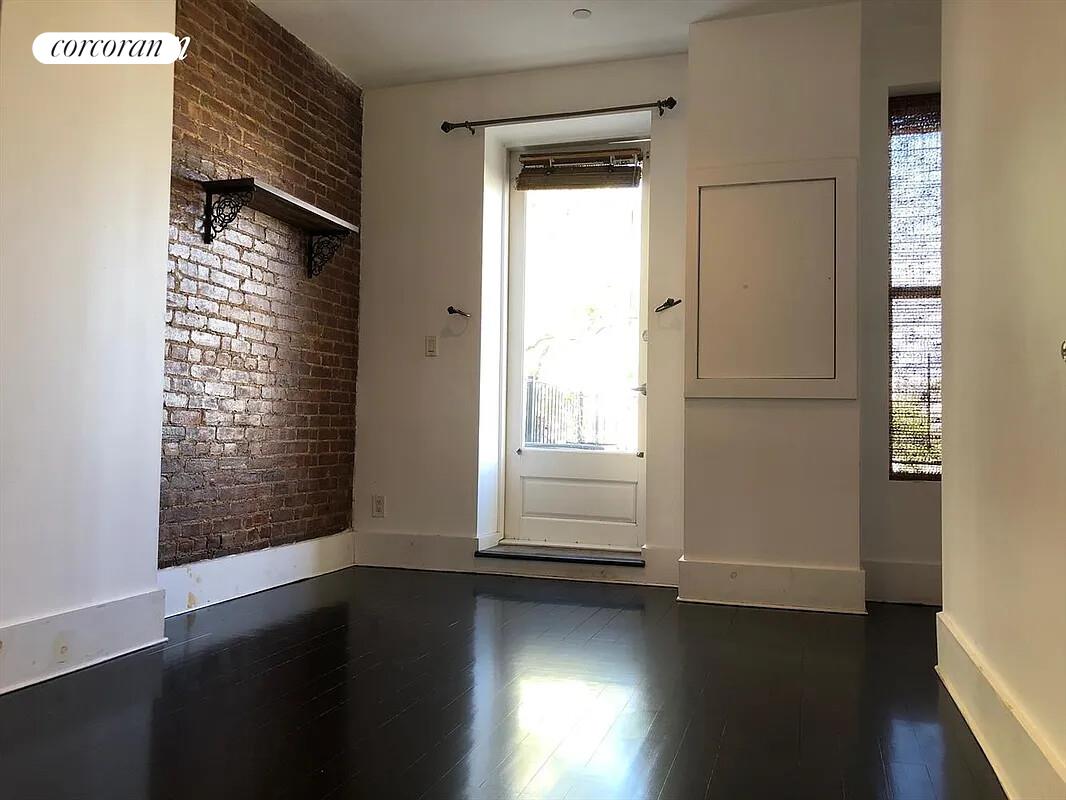 764 St Nicholas Avenue, Unit PH Manhattan, NY 10031 - Photo 9 of 14 an empty room with wooden floor and windows