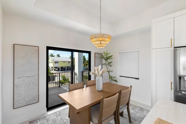 a kitchen with stainless steel appliances a white table chairs and a chandelier