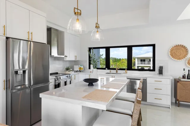 a dining room with furniture a chandelier and kitchen view