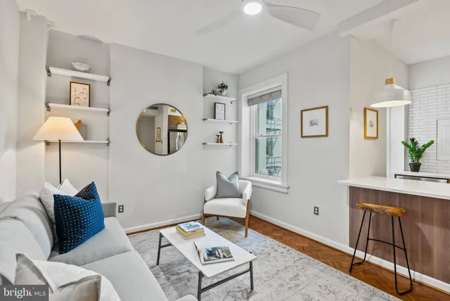 a living room with furniture and a painting on the wall