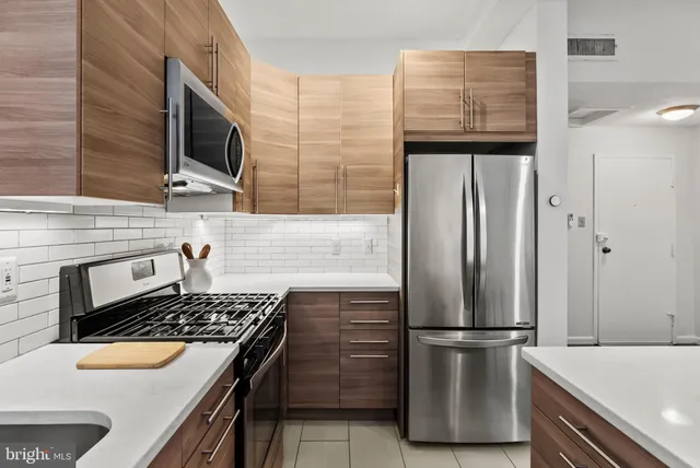 a kitchen with stainless steel appliances granite countertop a refrigerator and a stove top oven