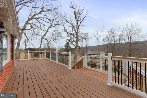 a view of a house with wooden deck next to a yard