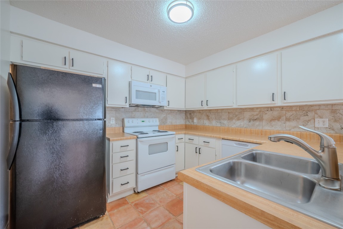 13034 Leader Street, Unit 960 Houston, TX 77072 - Photo 16 of 28 a kitchen with a refrigerator sink and cabinets